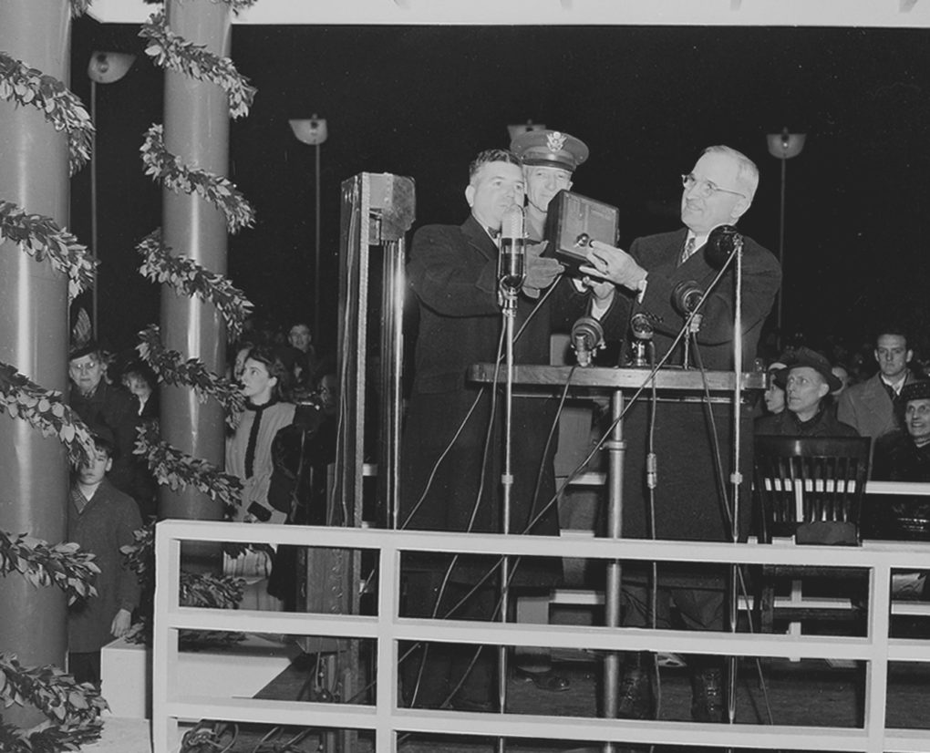 President Harry S. Truman, switching on the lights of the National Community Christmas Tree on the White House grounds, December 24, 1945. 