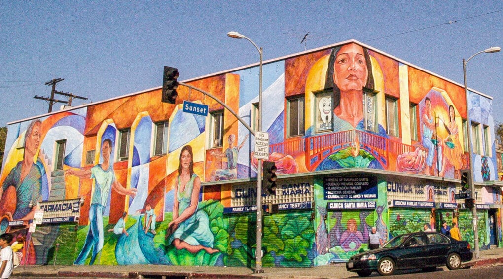 Orange mural with faces on bodega.
