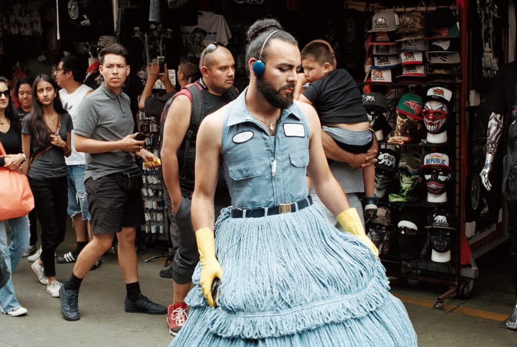 Man dressed in gown made of blue string mops.