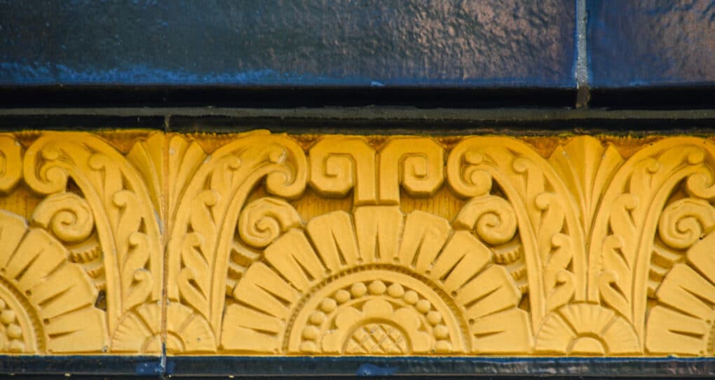 Gold tile work against black brick.