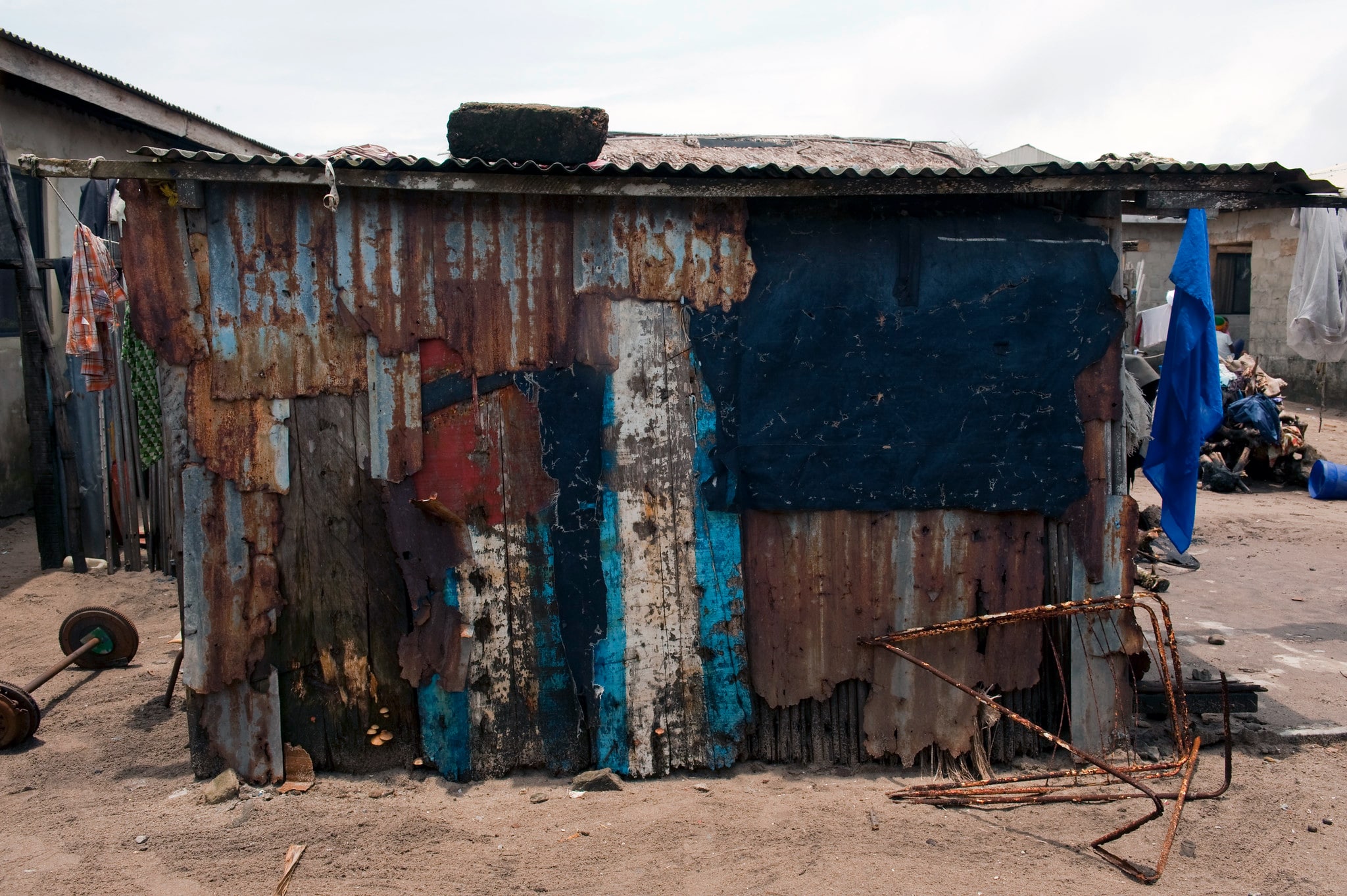 Click to Enlarge The backside of a lean-to, made from scraps of corrugated metal and other recused materials.