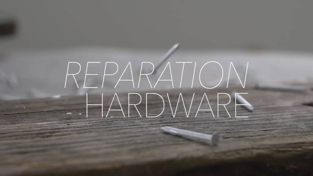 A title frame from a short film, showing the words Reparation Hardware over a close-up of nails falling on a board.