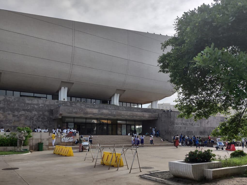 Color photograph of large concrete building with curving upper story and glass mezzanines.
