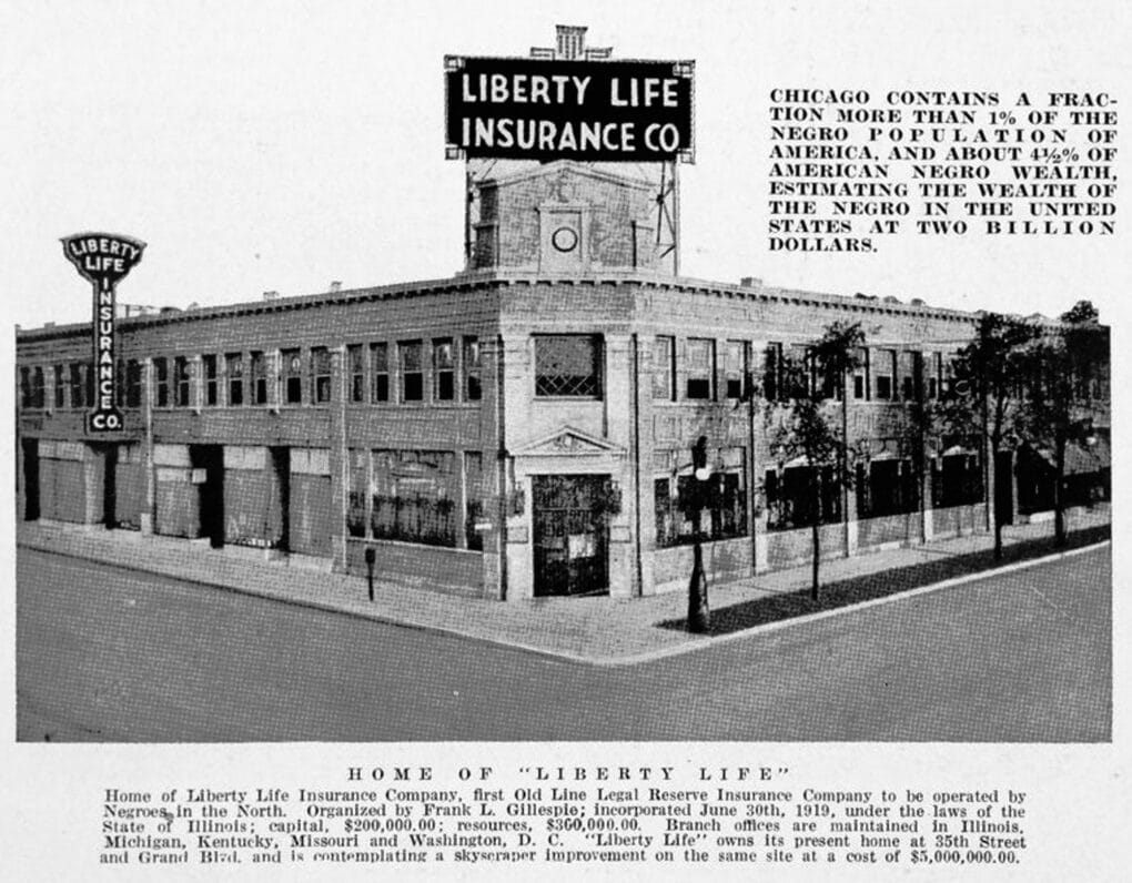 Black-and-white photograph of large two-story brick building, with large sign on the roof reading "Liberty Life Insurance Co."
