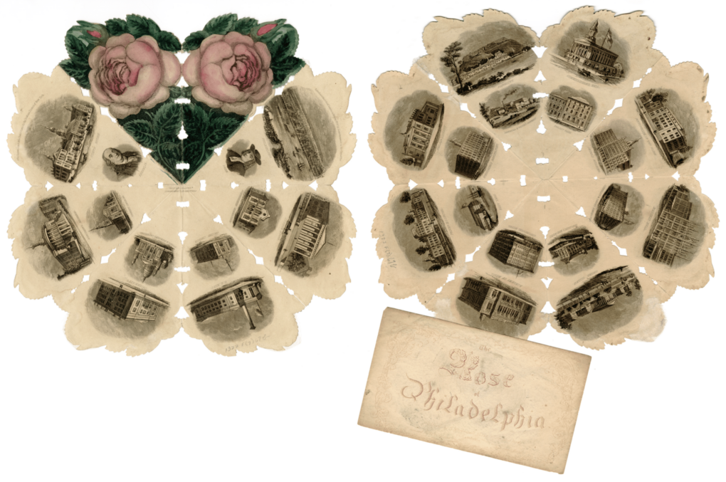 Elaborate cut-out paper, unfolded and lying flat, with pink roses and vignette images of important civic buildings in Philadelphia.