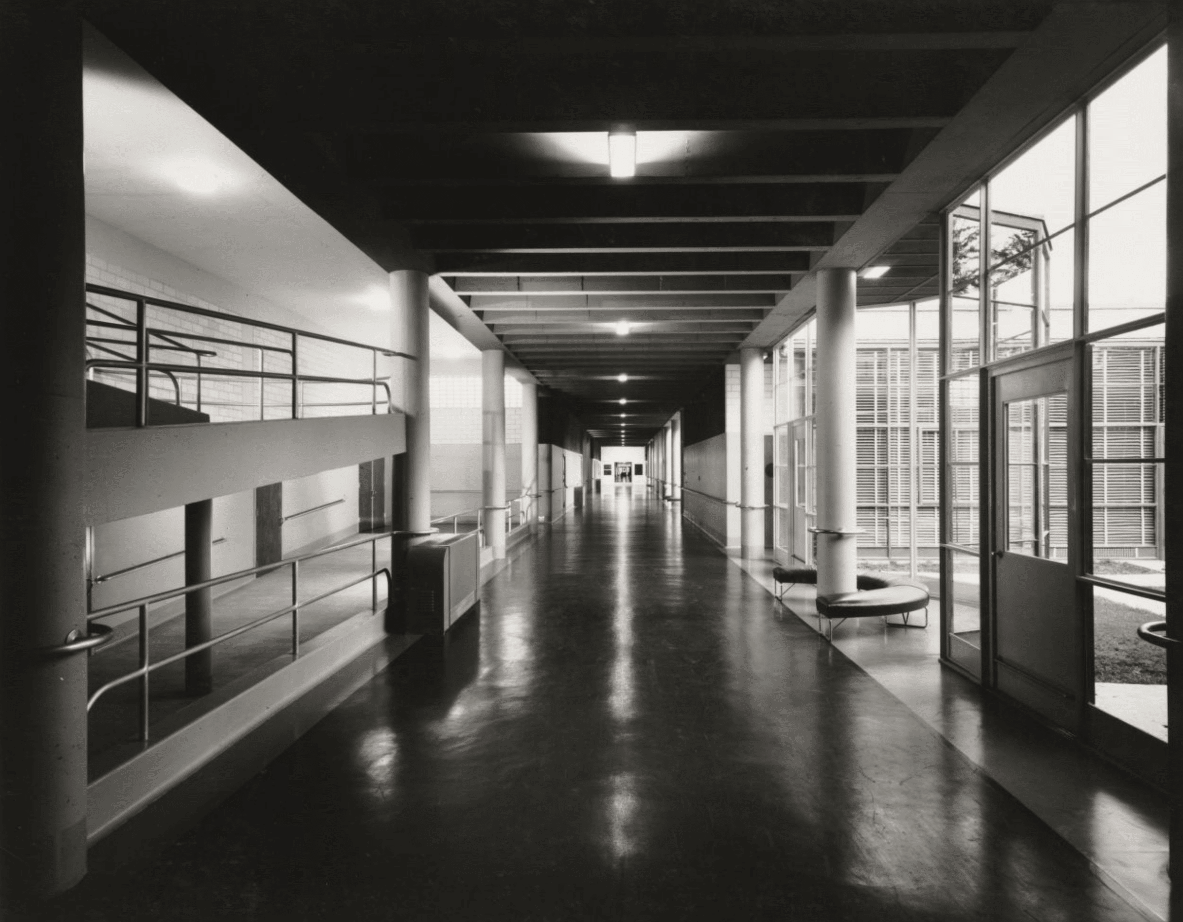 Click to Enlarge Hallway of school with glass atrium on right and wide ramp on left. Photographic documentation of architecture — no students are present.