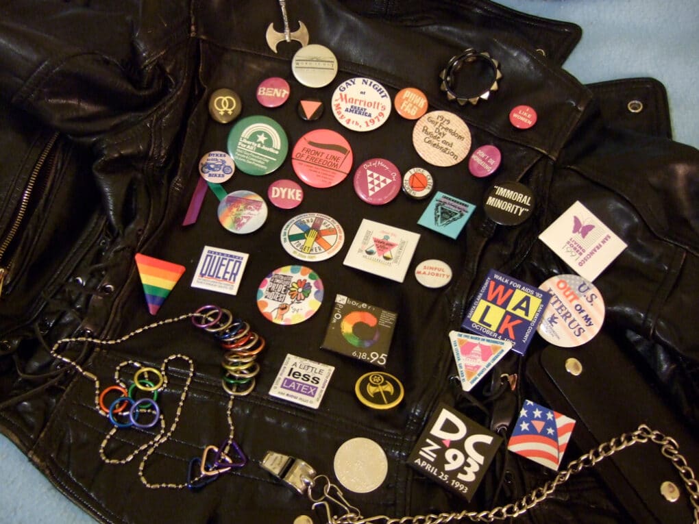 Color photograph of political buttons laid out on a black leather jacket.