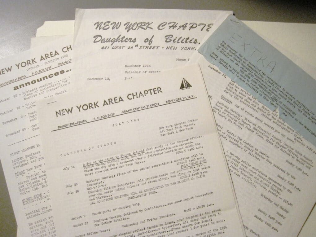 Color photograph of black-and-white mimeographed newsletters.