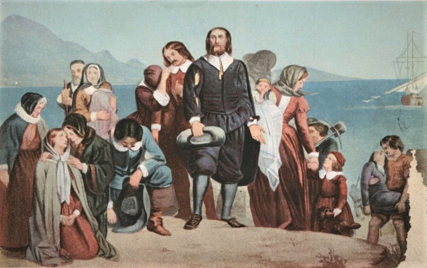 Color reproduction of painting showing a Pilgrim father surrounded by women and children on waterside rock, with ship in the background.