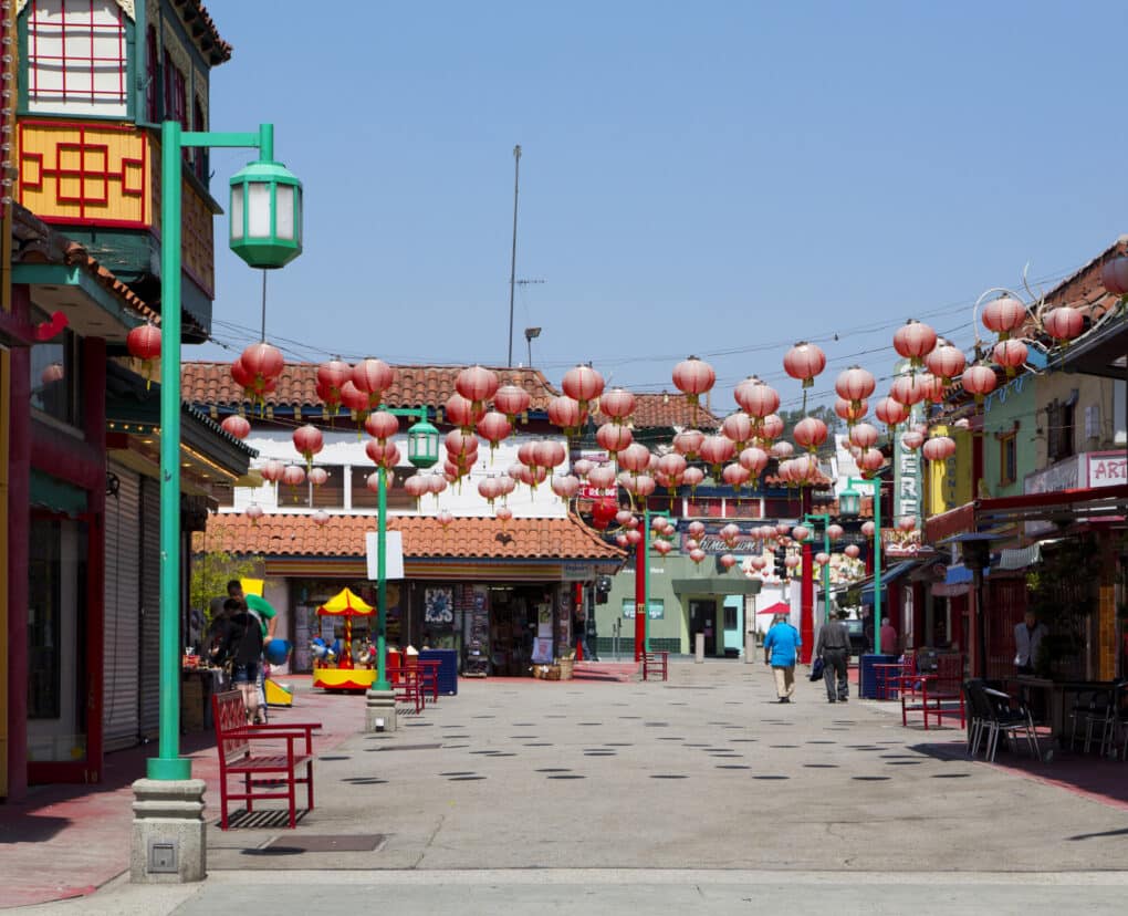 Color photo of Los Angeles Chinatown plaza with many red lanterns hanging overhead.