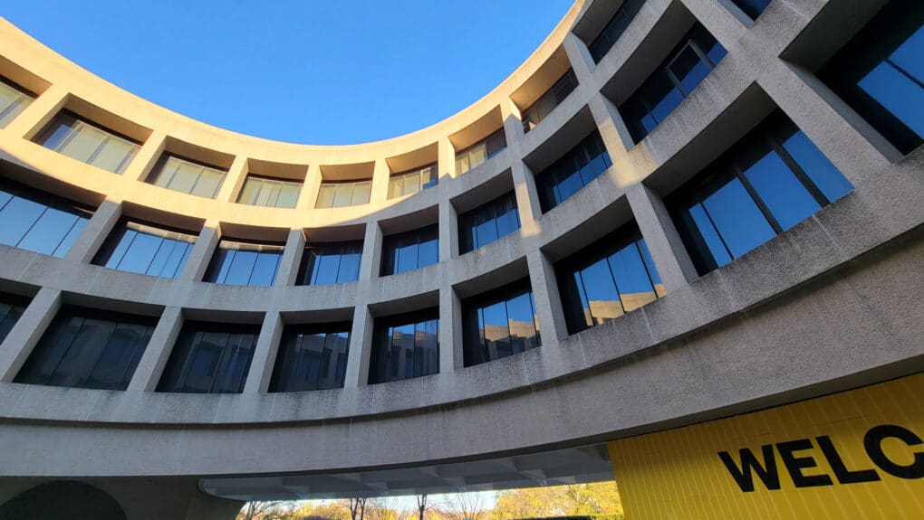 Color photograph showing inner curve of circular concrete brutalist building.