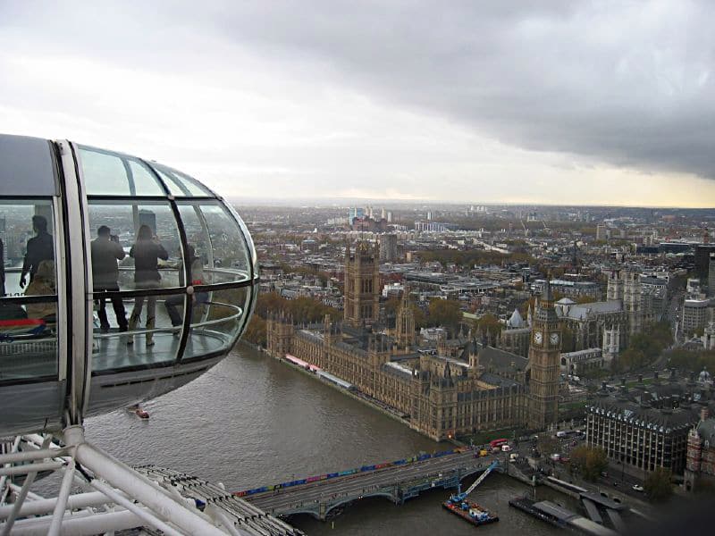 Color photograph of London rooftops with capusle of Ferris wheel in immediate foreground at left.
