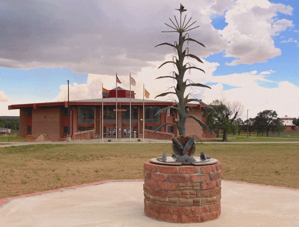 At Dine College, in Tsaile, Arizona, the hogan-shaped library, with a sculpture of the sacred cornstalk in the foreground, is the focal point and interpretive key to the campus.