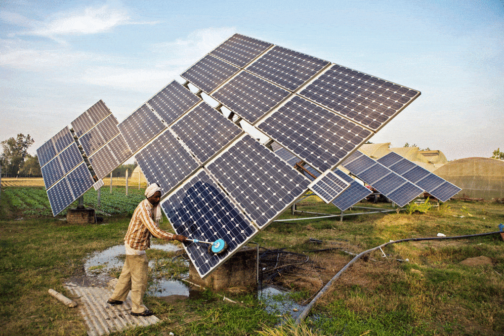 Farmworker cleans solar panels at the farm in Jagadhri, India, 2014.