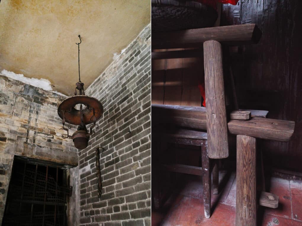 On the left is a rusty lamp hanging from the ceiling; on the right is cluttered stack of simple wood benches.