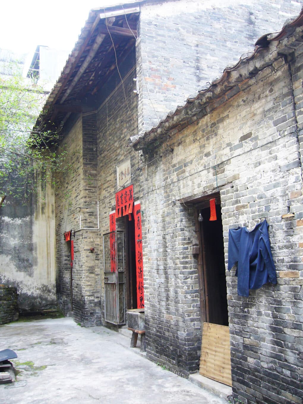 A brick building with an entrance plaque and several red banners.