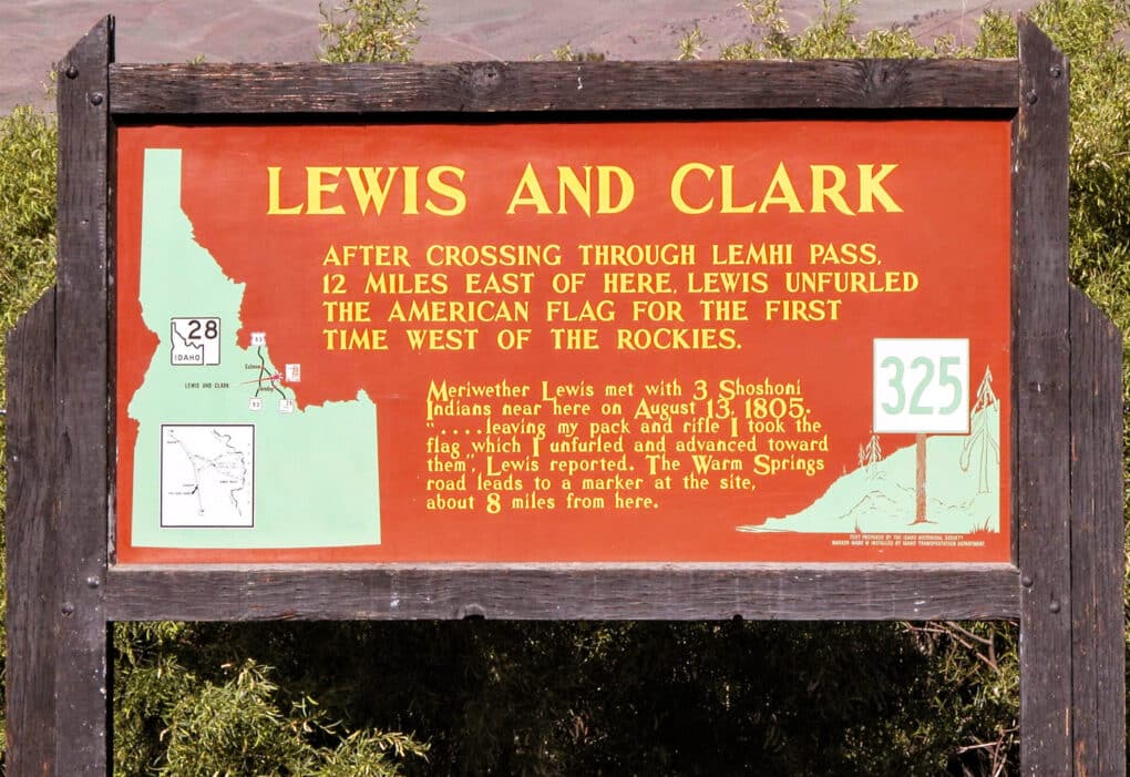 Photo of sign with text announcing the locations where Lewis and Clark "unfurled the American flag for the first time west of the Rockies." An accompanying map of Idaho pinpoints the location. 