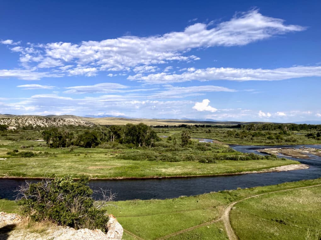 Color landscape photos of two calm rivers joining together, lush greenery surrounding. 