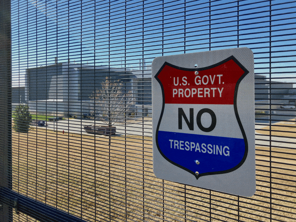 Photograph of the National Bio and Agro-Defense Facility, in Manhattan, Kansas, showing a high-security fence and a "No Trespassing" sign.