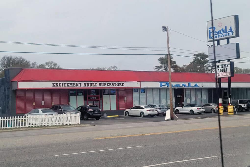 Color photograph of side-by-side adult bookstore and cabaret in a roadside mini mall.