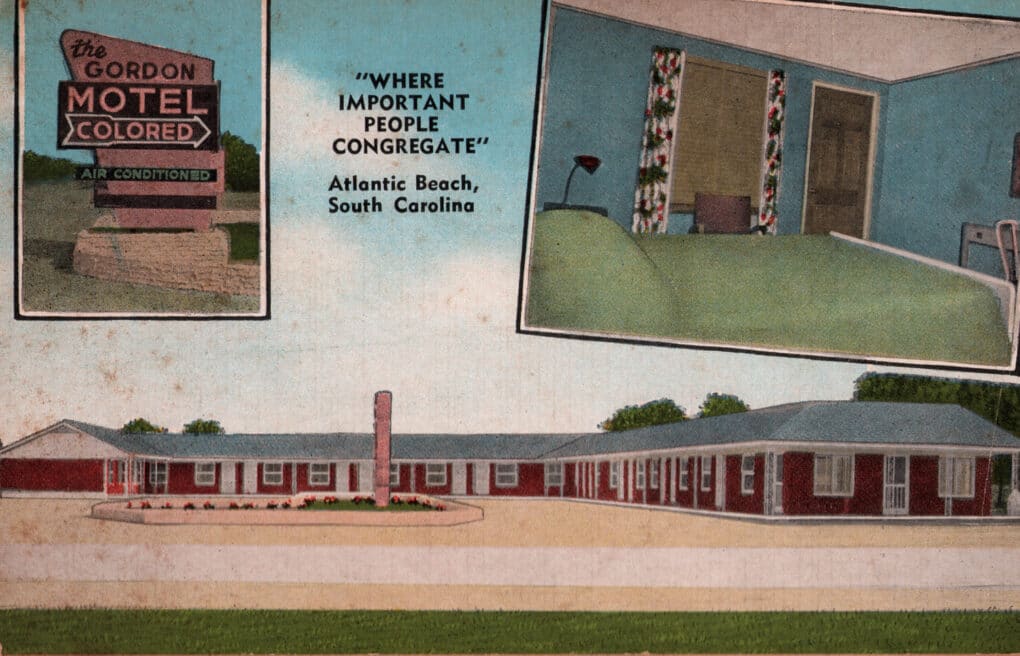 Colorized postcard showing motel with a sign for "COLORED" accommodation.