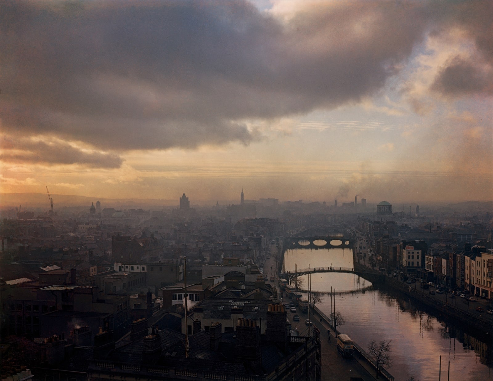 Color photograph of the city of Dublin and the River Liffey under a cloudy sky.