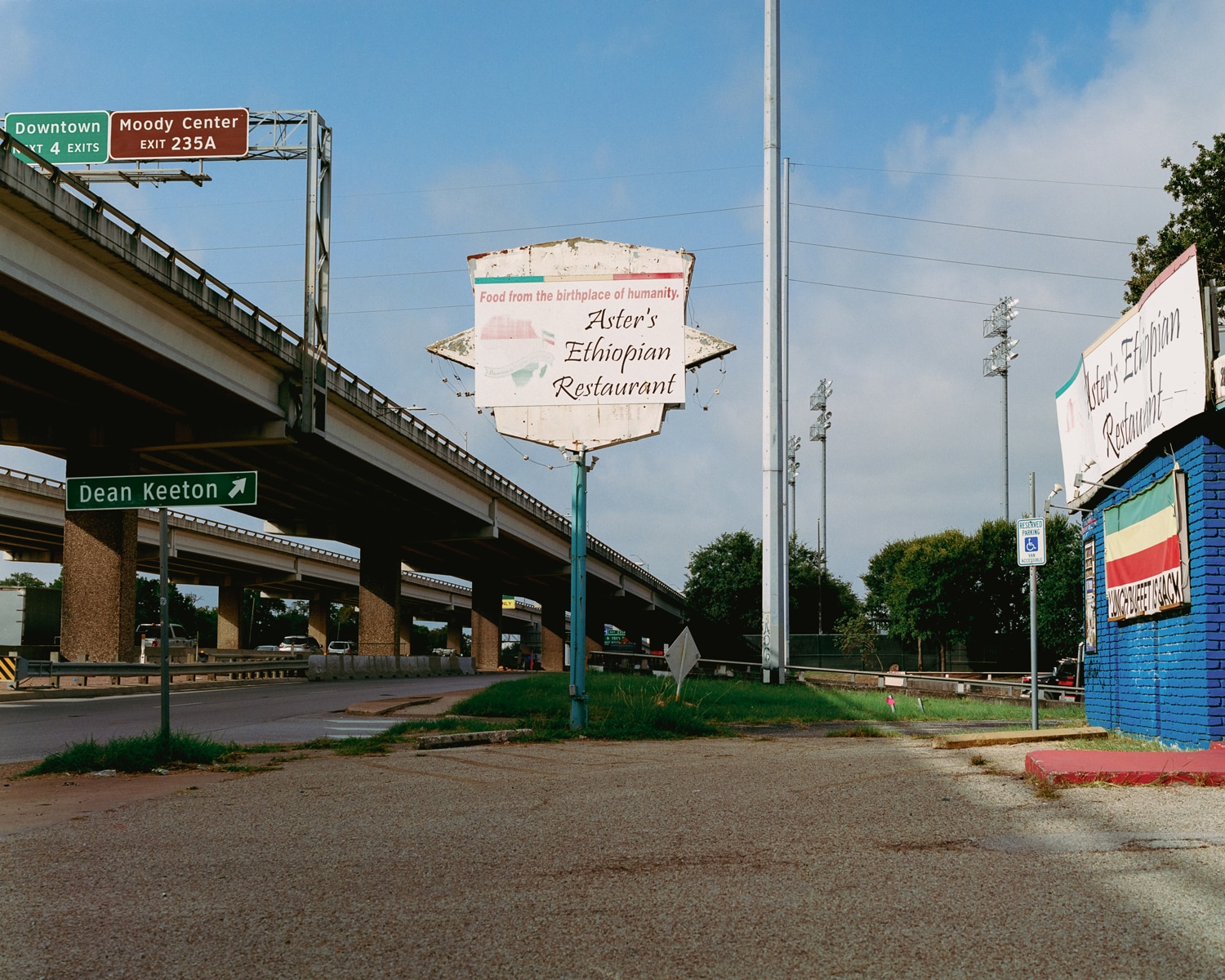 Click to Enlarge Color photograph of sign reading ASTER'S ETHIOPIAN RESTAURANT beside elevated freeway.