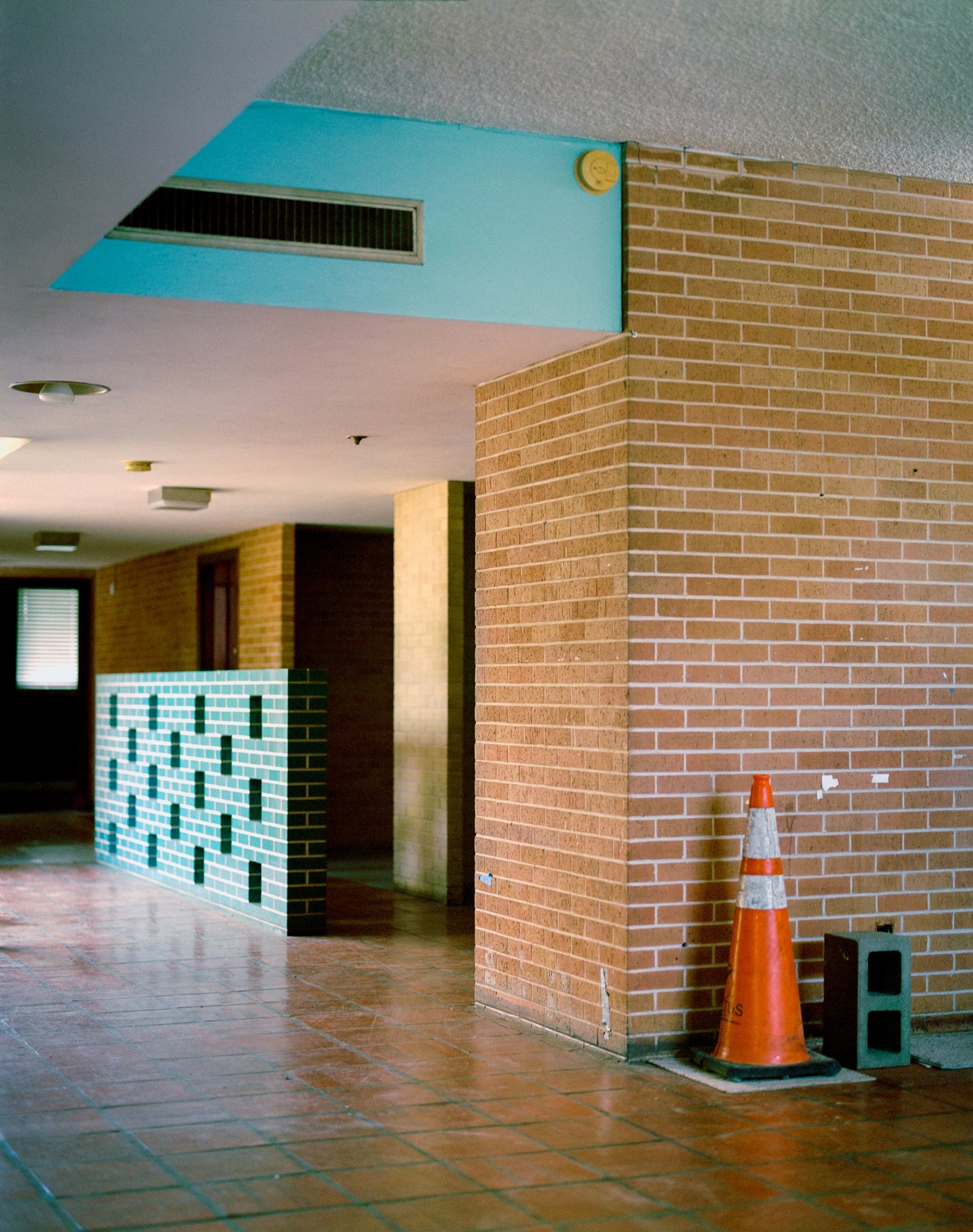 Click to Enlarge Color photograph of the interior of a public building, with brick and turquoise tilework.