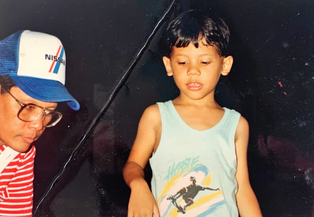 Color photograph of a young Chamorro man and a small boy.