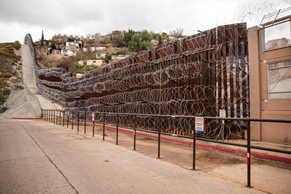 Wall stretching into the distance is clad in five coils of wire, top to bottom. 