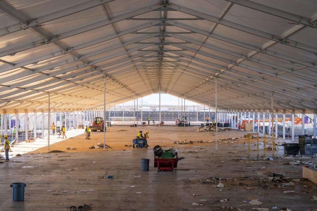 Photo of floor being torn up from large tent style structure. 