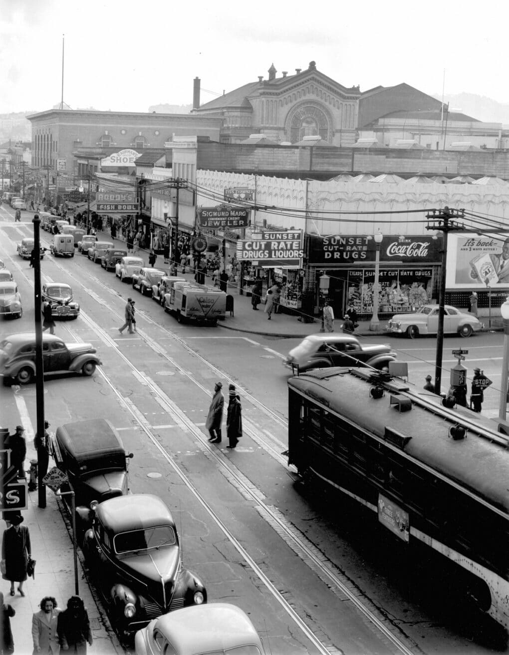 Black-and-white photograph of prosperous and populated mains street with Black pedestrians.