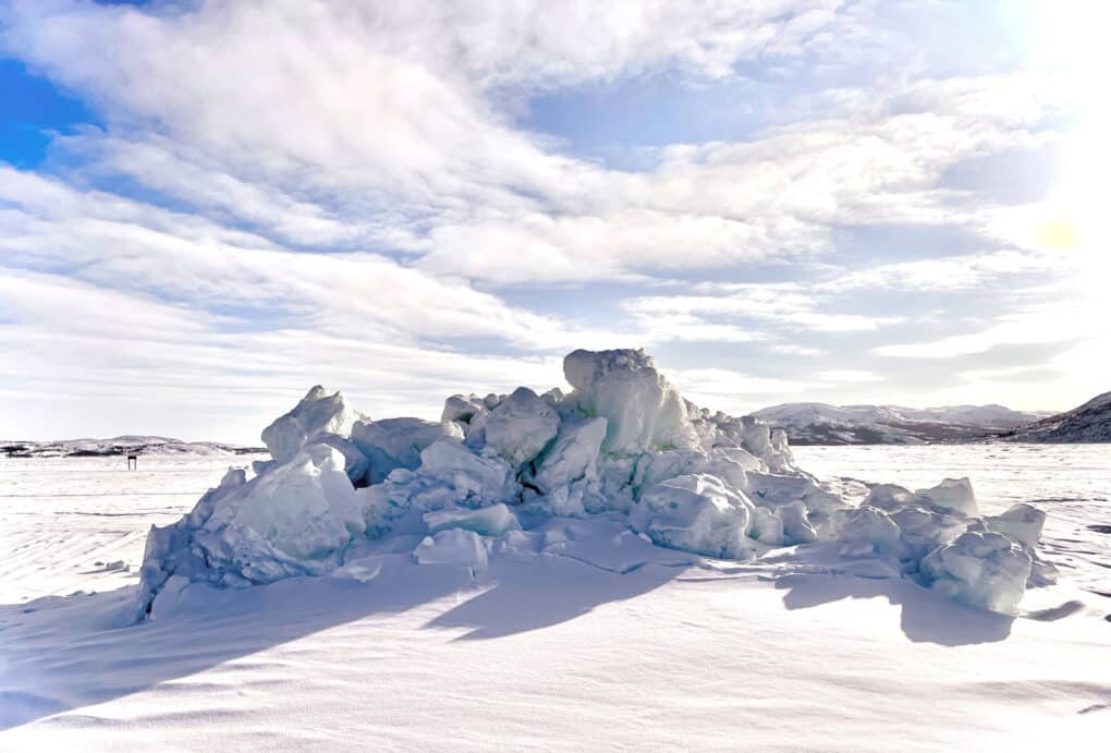A tall jumble of ice and snow, interrupting an otherwise flat expanse. 