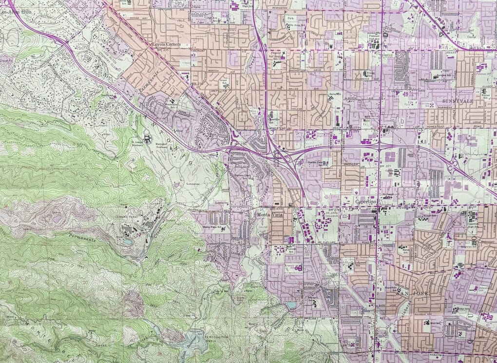 Street map in pink, purple, and green, showing path of highways through square city blocks.